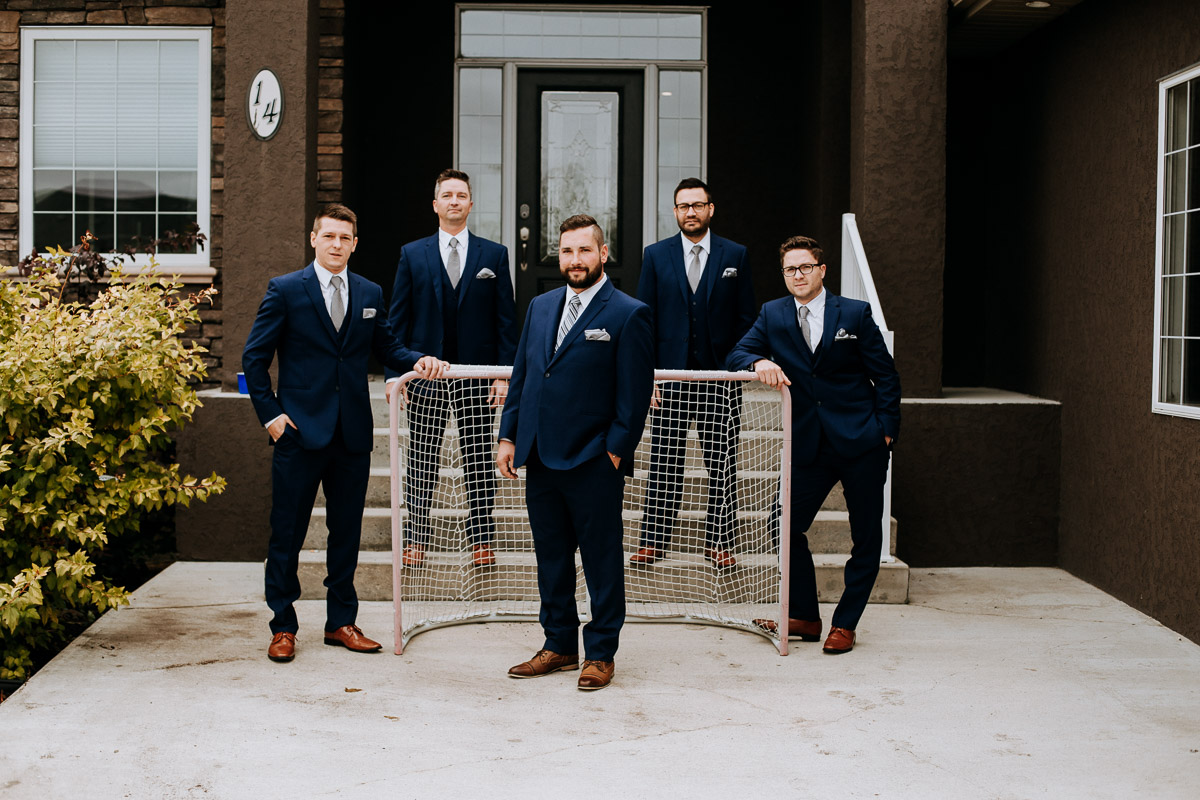 Colt and his groomsmen in front of hockey net in Niverville Manitoba